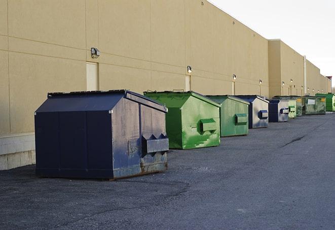 a series of colorful, utilitarian dumpsters deployed in a construction site in Butler